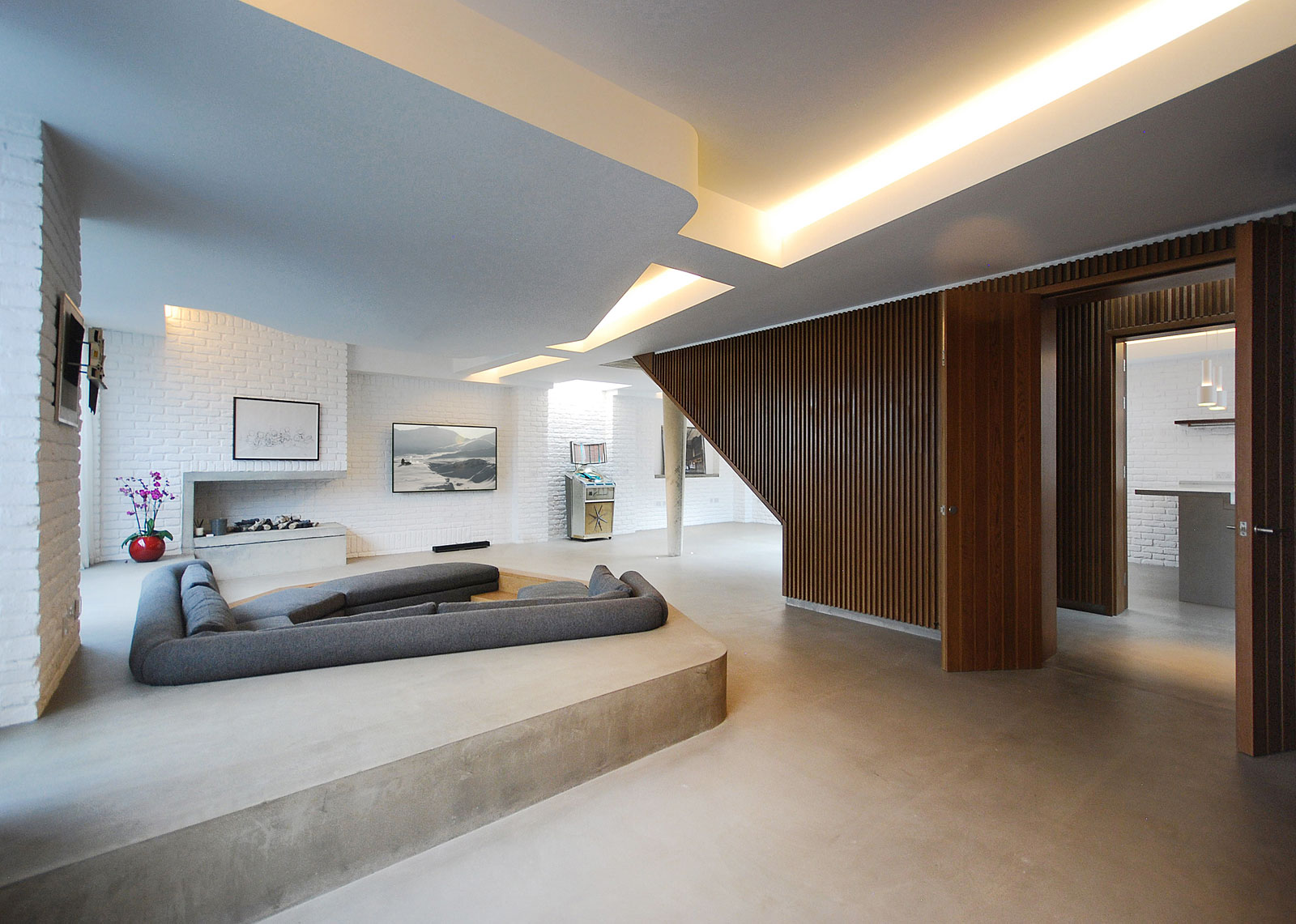 Contemporary interior featuring concrete floor, sunken seating area, brick walls and timber cladding